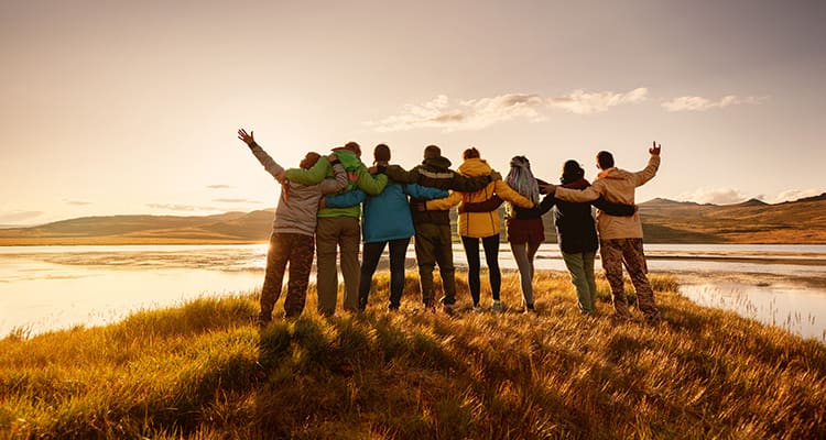 A group of hikers embrace in the wilderness