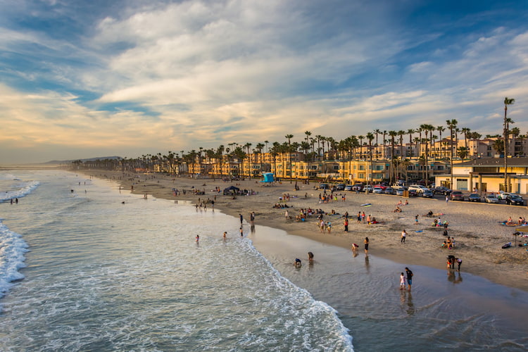 a view of the Oceanside City Beach coastline at dusk on a partly cloudy day