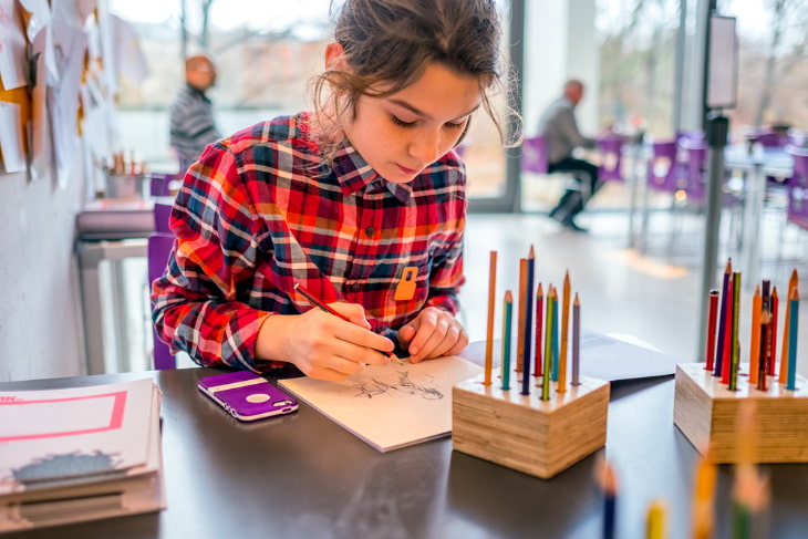 a girl in a plaid shirt drawing