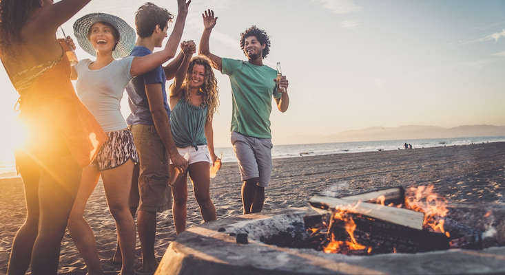 five friends gather around a fire pit at Ocean Beach in San Francisco